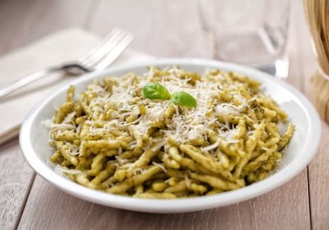 photo of pesto pasta with parmesan on top
